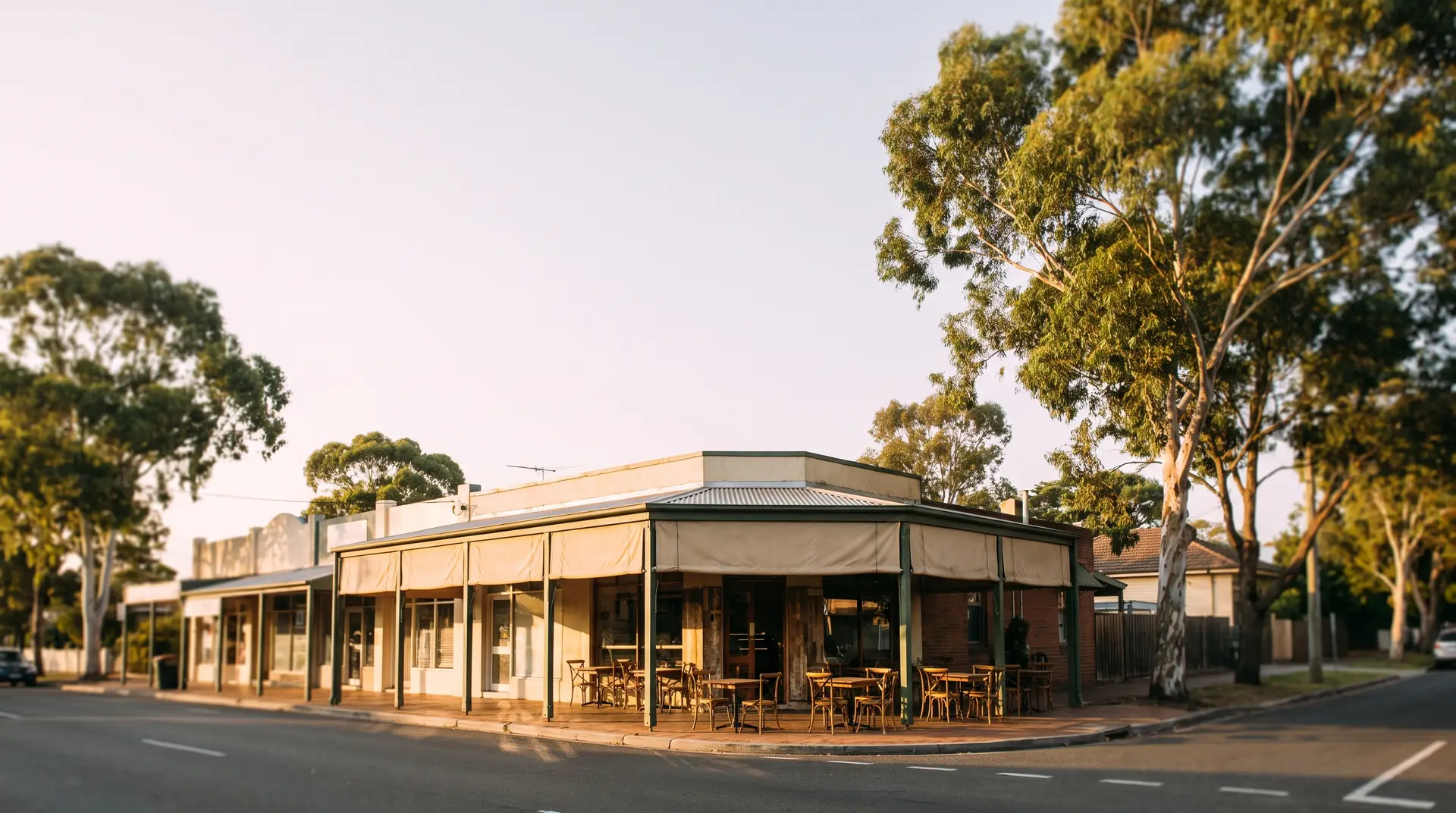 A sunlit strip of small Australian shopfronts in the morning